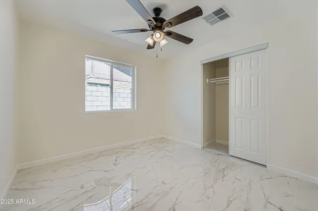 an empty room with a window and a fan