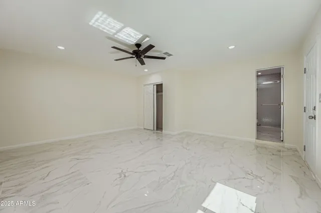 an empty room with windows and fan