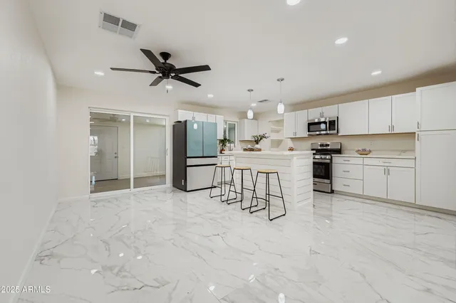 a kitchen with a sink a stove a refrigerator and white cabinets