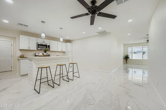 a kitchen with kitchen island a counter top space appliances and cabinets