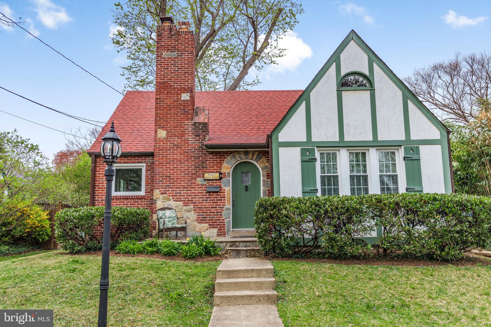 a front view of a house with a yard and potted plants