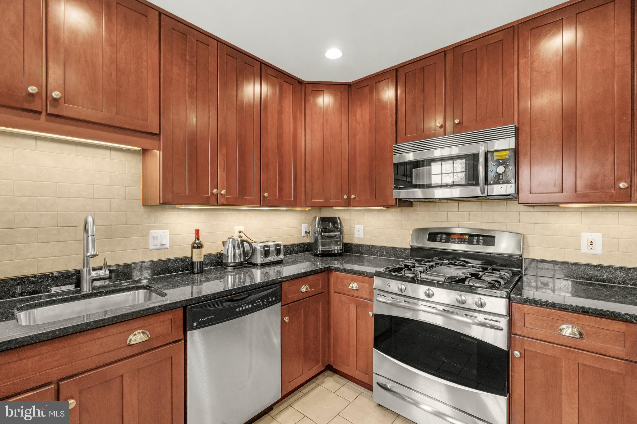 9505 Riley Road Silver Spring, MD 20910 - Photo 12 of 41 a kitchen with granite countertop wooden cabinets and stainless steel appliances