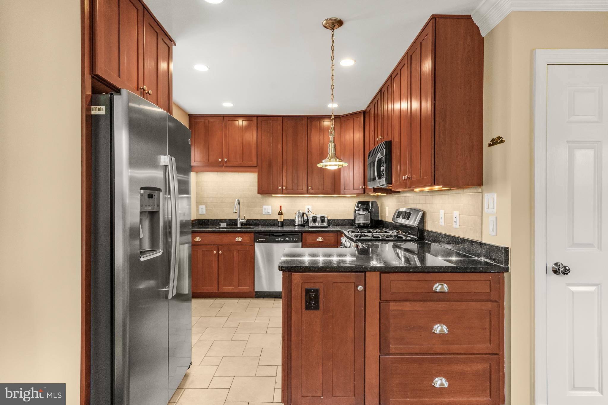 9505 Riley Road Silver Spring, MD 20910 - Photo 13 of 41 a kitchen with stainless steel appliances granite countertop a refrigerator a sink and a stove