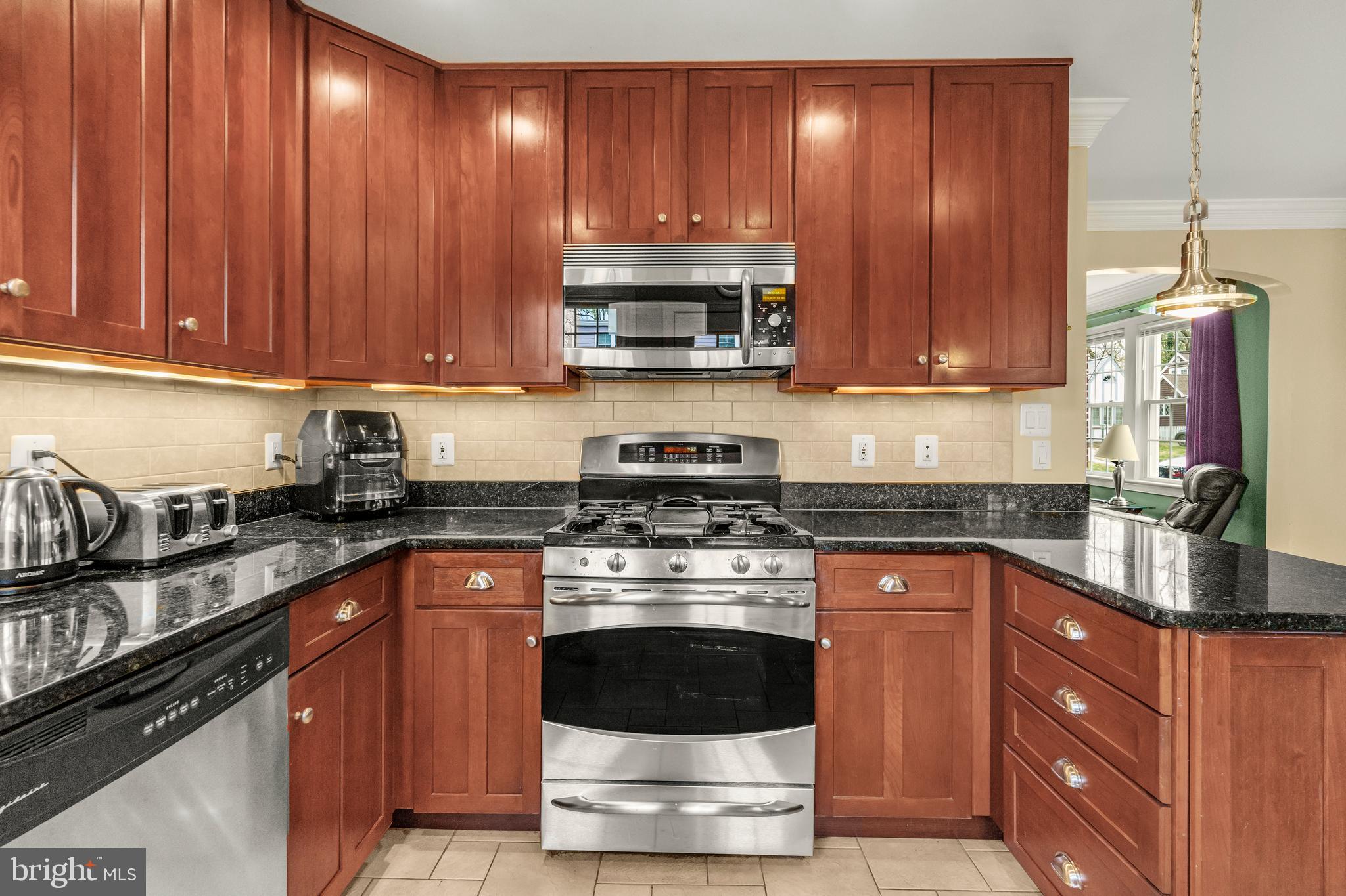 9505 Riley Road Silver Spring, MD 20910 - Photo 14 of 41 a kitchen with granite countertop wooden cabinets and stainless steel appliances