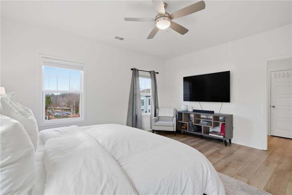 3158 Webb Road Milton, GA 30004 - Photo 19 of 36 a bedroom with a bed a flat screen tv and a chandelier