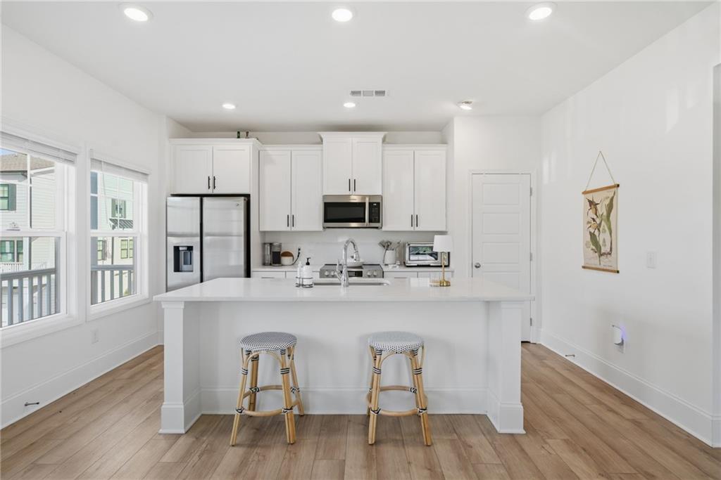 3158 Webb Road Milton, GA 30004 - Photo 9 of 36 a kitchen with stainless steel appliances white cabinets and wooden floor