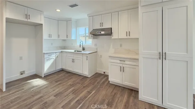 a kitchen with white cabinets and stainless steel appliances