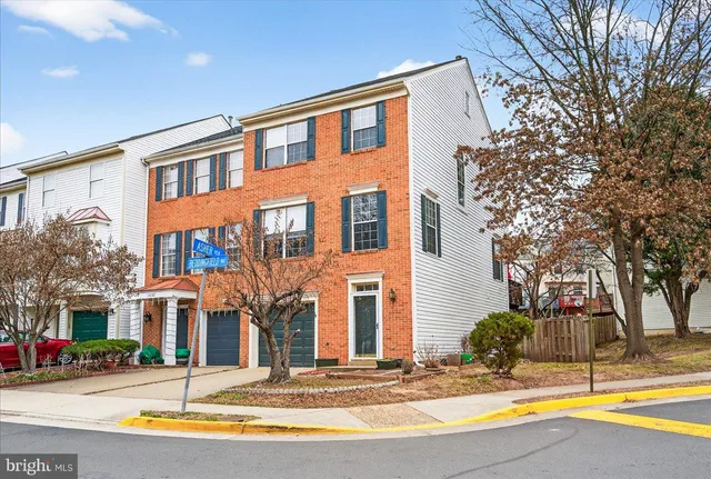 a view of a house with a small yard and large tree