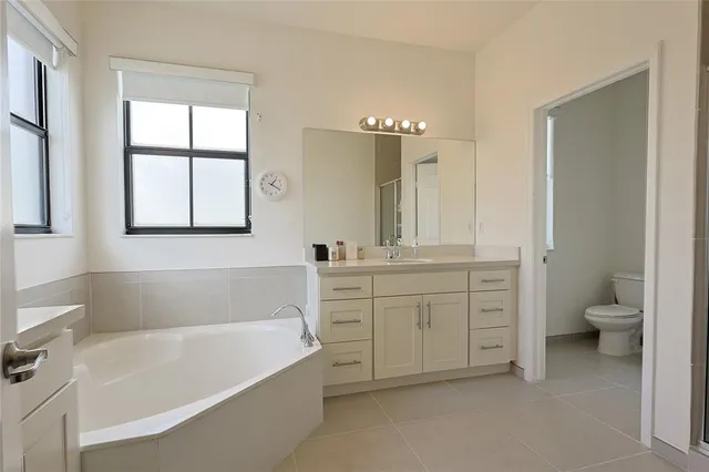 a bath room with a toilet a bath tub and a sink