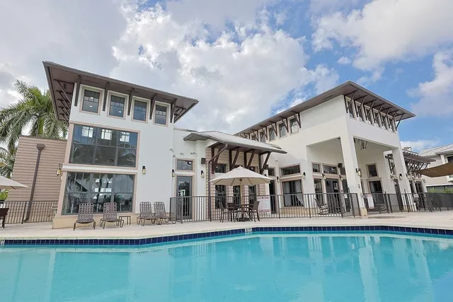 a view of a dining room with furniture and large windows