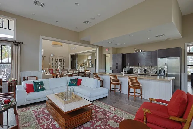 a dining room with wooden floor a chandelier a wooden table and chairs