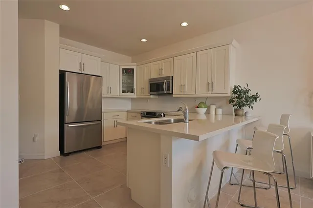 a kitchen with stainless steel appliances granite countertop a refrigerator stove microwave and sink