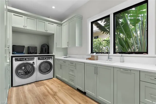 a utility room with sink dryer and washer