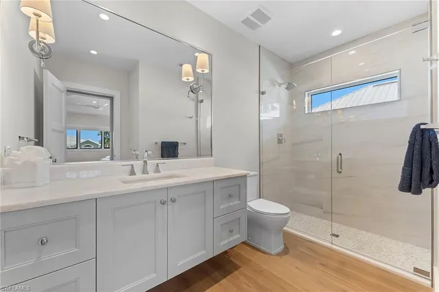 a bathroom with a double vanity sink toilet and shower