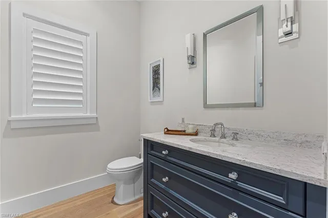 a bathroom with a granite countertop toilet sink and mirror