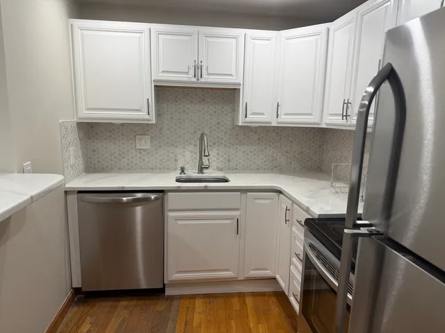 a kitchen with white cabinets and a sink