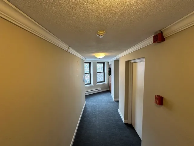 a view of an empty room with a fireplace and a window