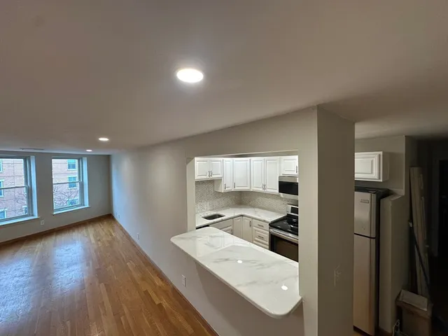 a kitchen with stainless steel appliances granite countertop a refrigerator and a stove top oven