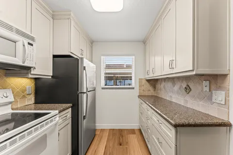a kitchen with a refrigerator stove and cabinets
