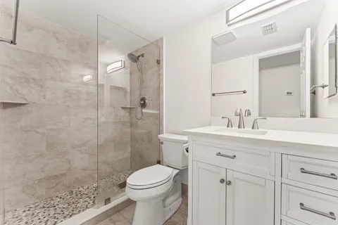 a bathroom with a sink mirror vanity and toilet