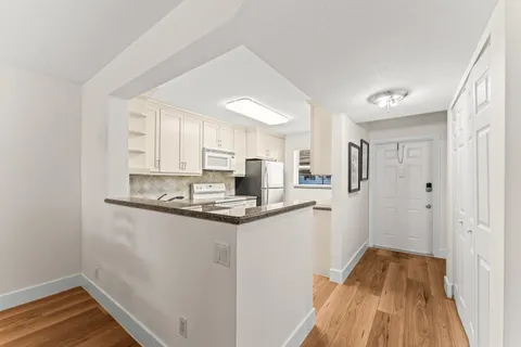 a kitchen with stainless steel appliances a sink and wooden floor