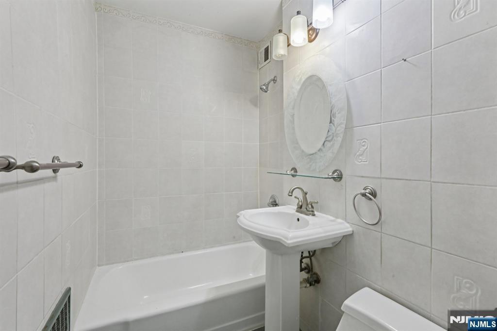 2160 Center, Unit 5N Fort Lee, NJ 07024 - Photo 18 of 30 a bathroom with a sink a toilet and bathtub