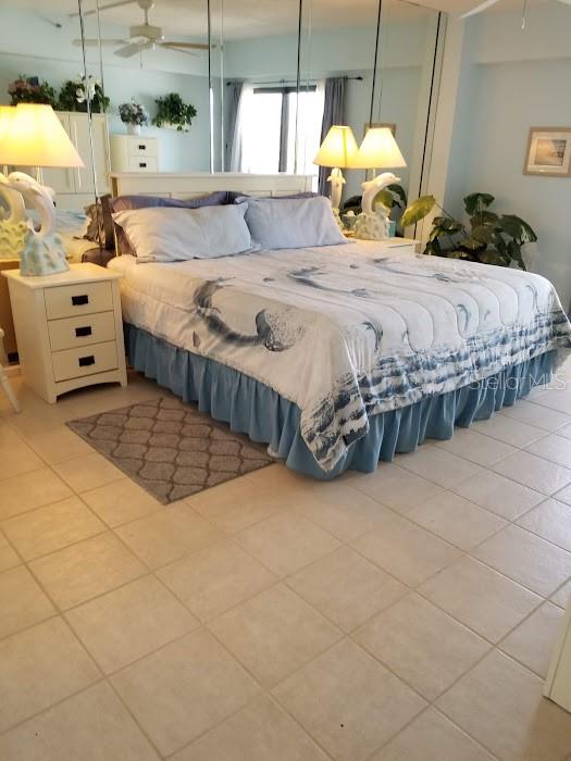 13650 Gulf Boulevard, Unit 304 Madeira Beach, FL 33708 - Photo 34 of 63 a bedroom with a bed mirror and window