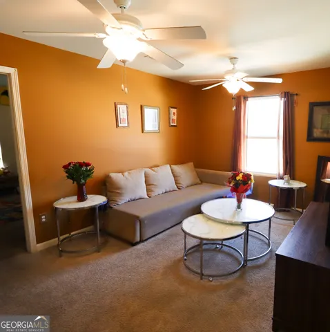 a living room with furniture a lamp and a potted plant
