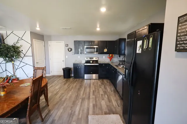 a kitchen with stainless steel appliances granite countertop a refrigerator and a stove top oven