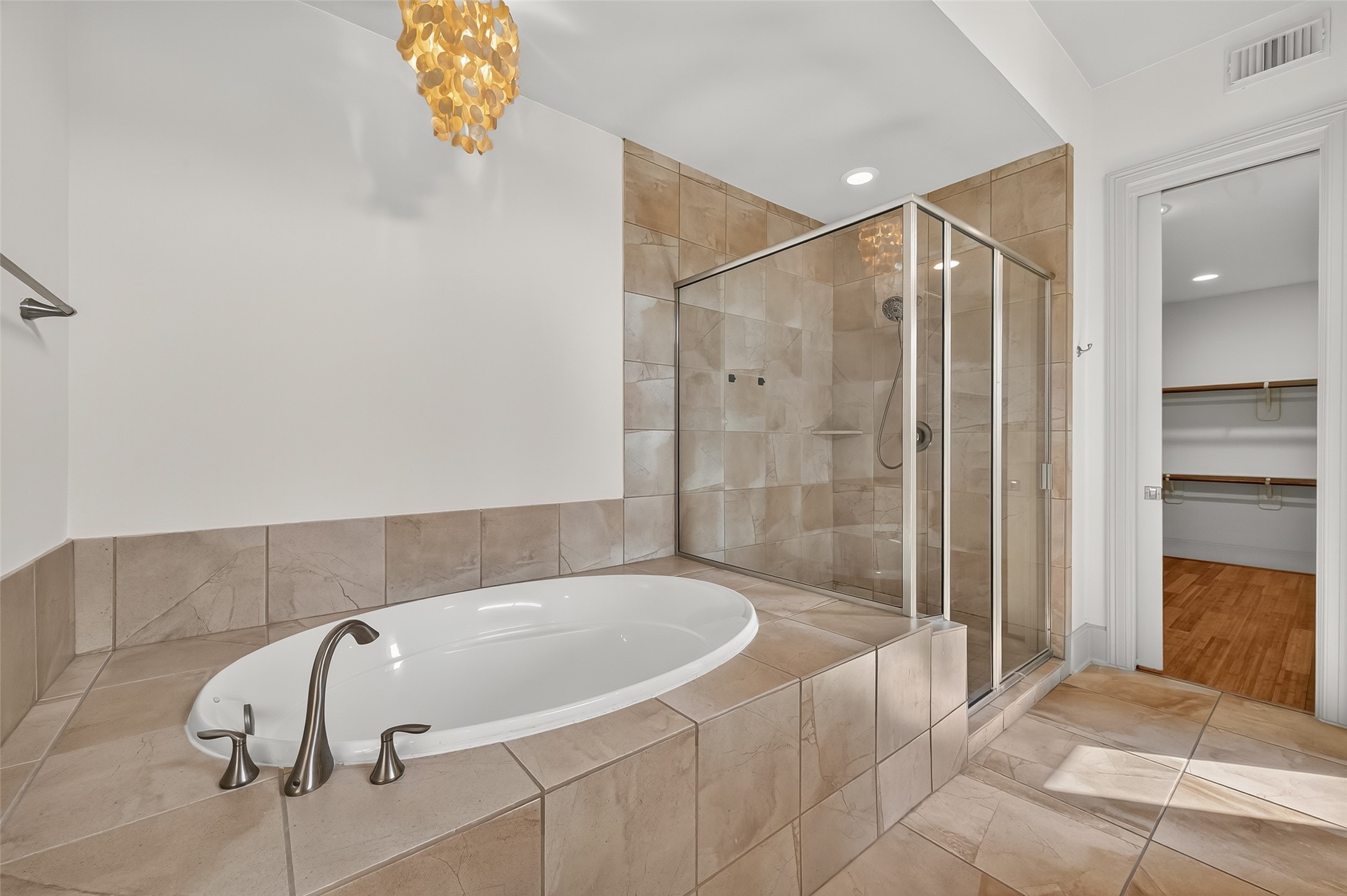 931 West 23rd Street, Unit K Houston, TX 77008 - Photo 19 of 40 Chandelier hangs over the soaking tub and adds a touch of elegance to the bathroom.