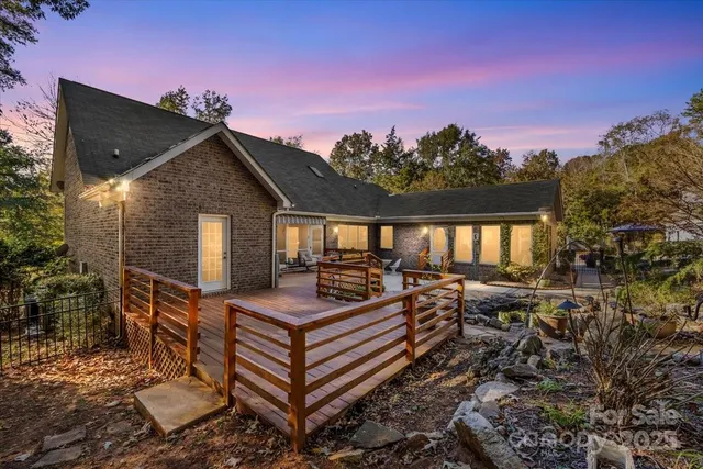a view of house with deck outdoor seating and wooden floor