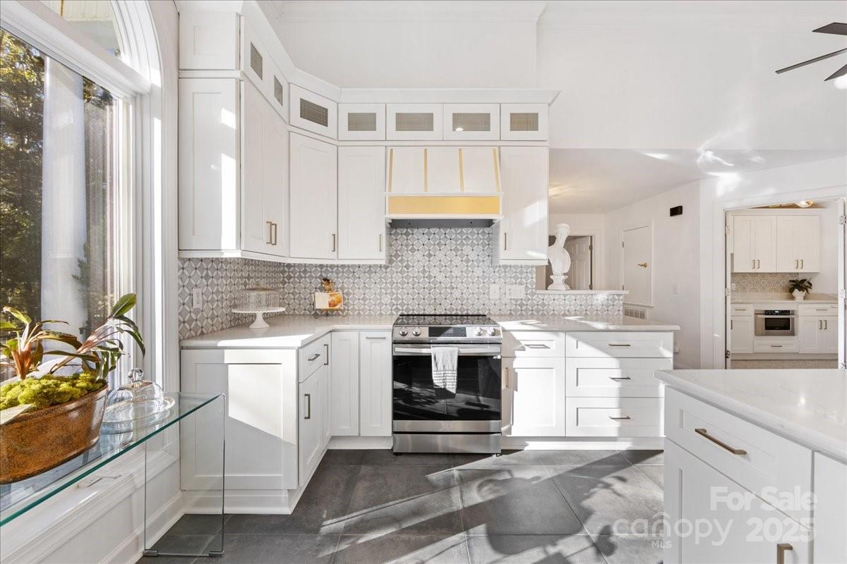 9701 Deer Run Road Waxhaw, NC 28173 - Photo 21 of 47 a kitchen with stainless steel appliances white cabinets and a stove top oven