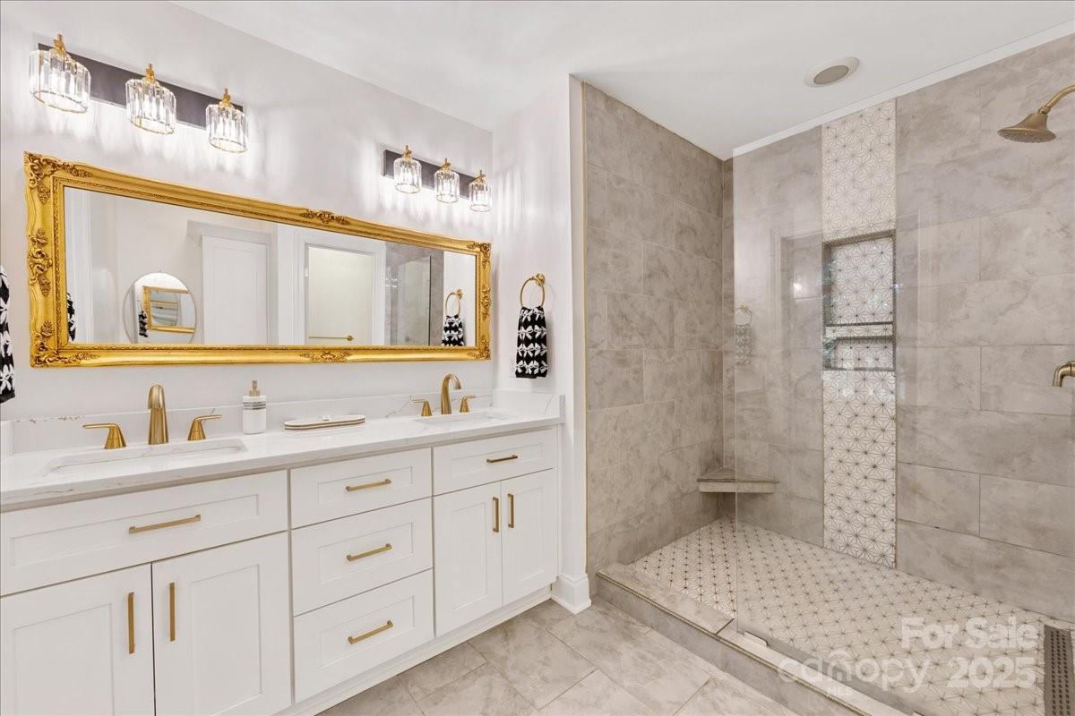 9701 Deer Run Road Waxhaw, NC 28173 - Photo 28 of 47 a bathroom with a double vanity sink mirror and shower