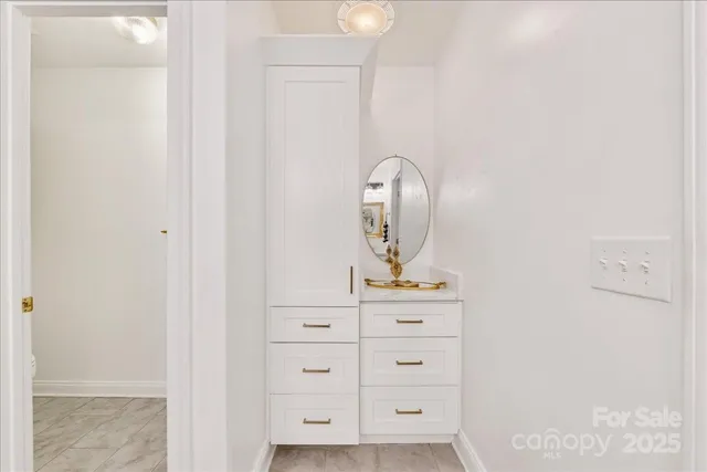 a kitchen with stainless steel appliances white cabinets and a wooden floor
