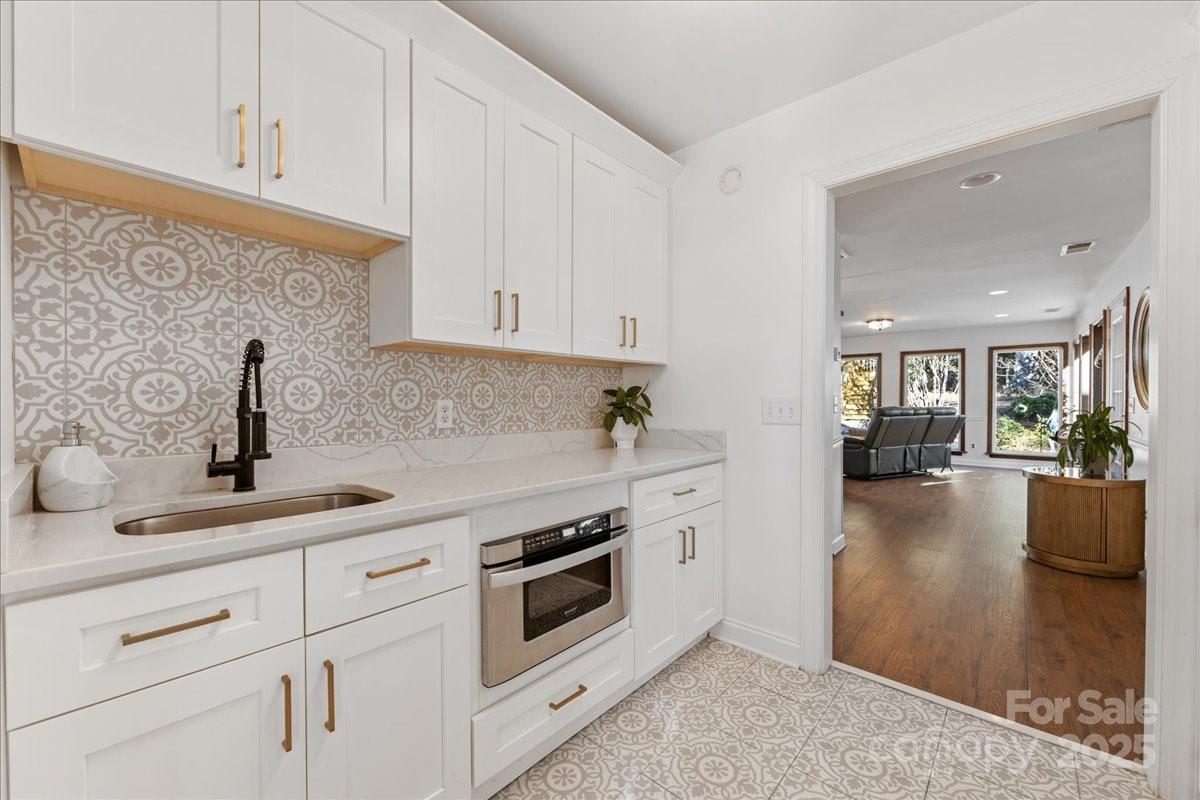 9701 Deer Run Road Waxhaw, NC 28173 - Photo 31 of 47 a kitchen with stainless steel appliances white cabinets and a wooden floor