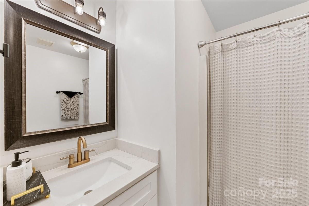 9701 Deer Run Road Waxhaw, NC 28173 - Photo 37 of 47 a bathroom with a sink a mirror and a shower