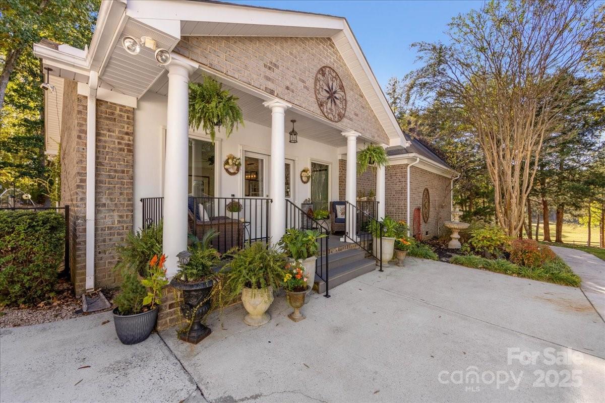 9701 Deer Run Road Waxhaw, NC 28173 - Photo 8 of 47 a view of a patio with couches and a table and chairs under an umbrella