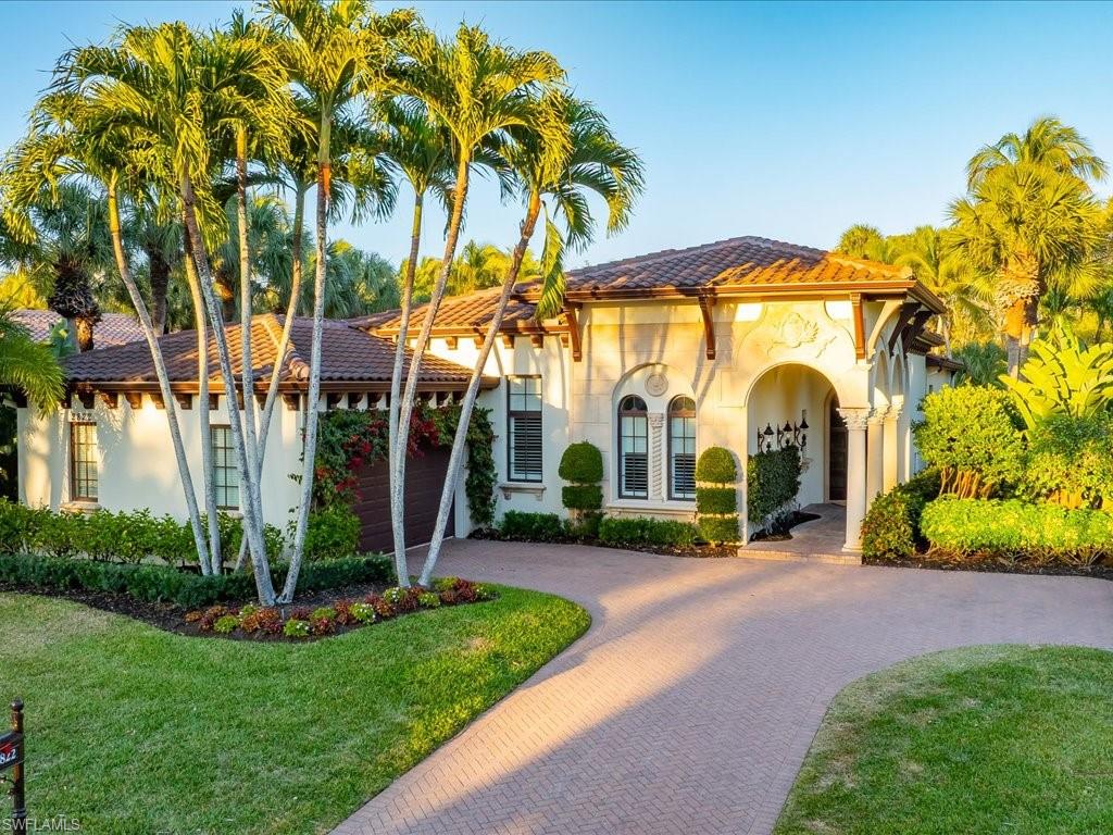 Lovely Home in Grey Oaks Country Club featuring a tile roof, curved paver driveway, stucco siding.