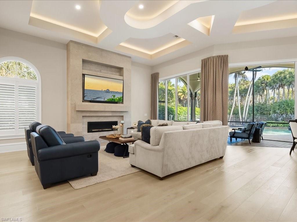 2822 Capistrano Way Naples, FL 34105 - Photo 11 of 47 Living room with European White Oak wood floors, a large gas fireplace, and striking custom coffered ceilings detailing.