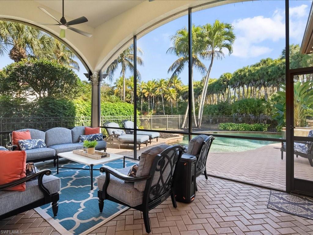 2822 Capistrano Way Naples, FL 34105 - Photo 21 of 47 Pavered screened in lanai looking onto the pool area, fenced yard and waterfalls in the adjacent lake.