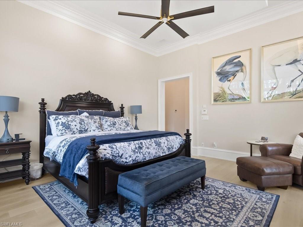 2822 Capistrano Way Naples, FL 34105 - Photo 23 of 47 Primary bedroom suite with french doors to the pool and lovely views of the landscaping and waterfalls and European White Oak wood flooring.