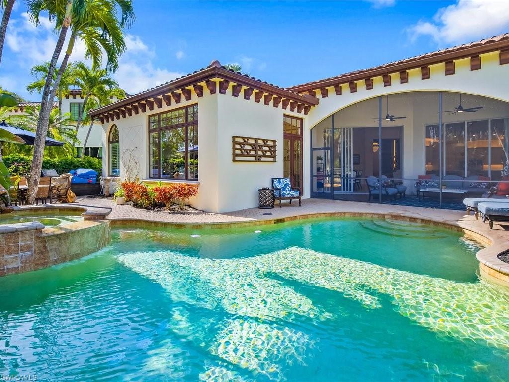 2822 Capistrano Way Naples, FL 34105 - Photo 35 of 47 Heated pool and spa with large patio, dining area and lounge chairs.