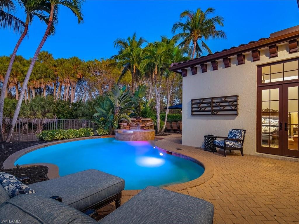 2822 Capistrano Way Naples, FL 34105 - Photo 36 of 47 Heated pool and spa with large patio, dining area and lounge chairs.