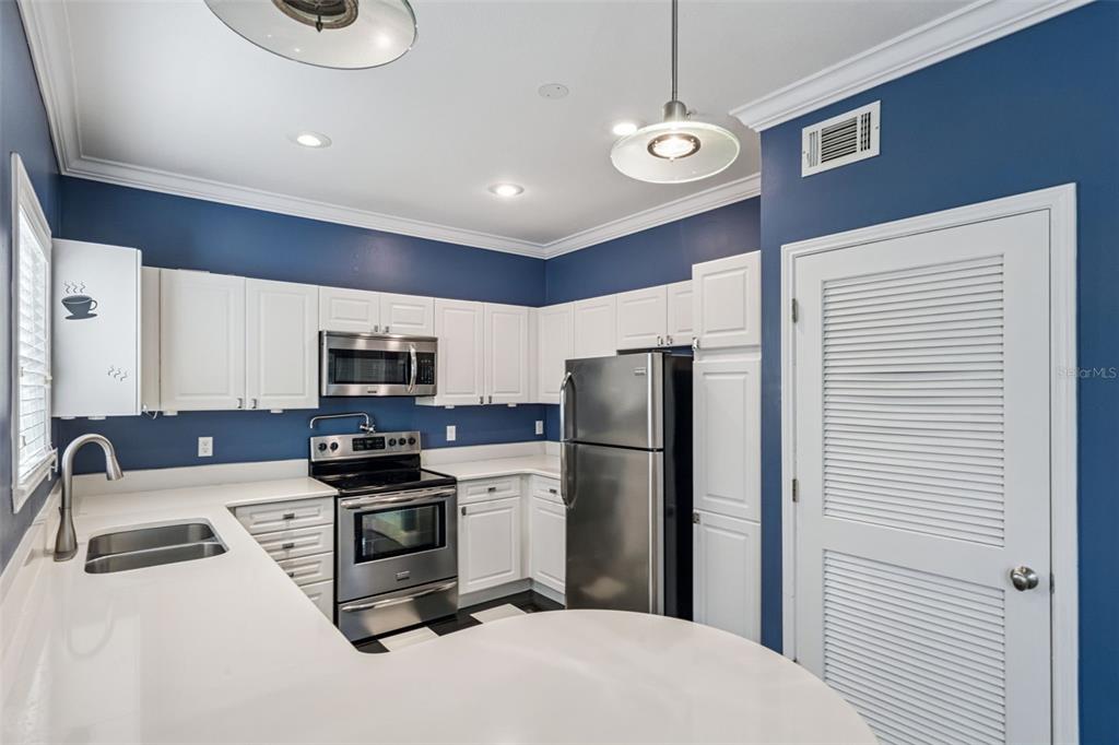 414 Water Street, Unit 414 Celebration, FL 34747 - Photo 13 of 75 a kitchen with stainless steel appliances granite countertop a refrigerator a stove a sink and a microwave