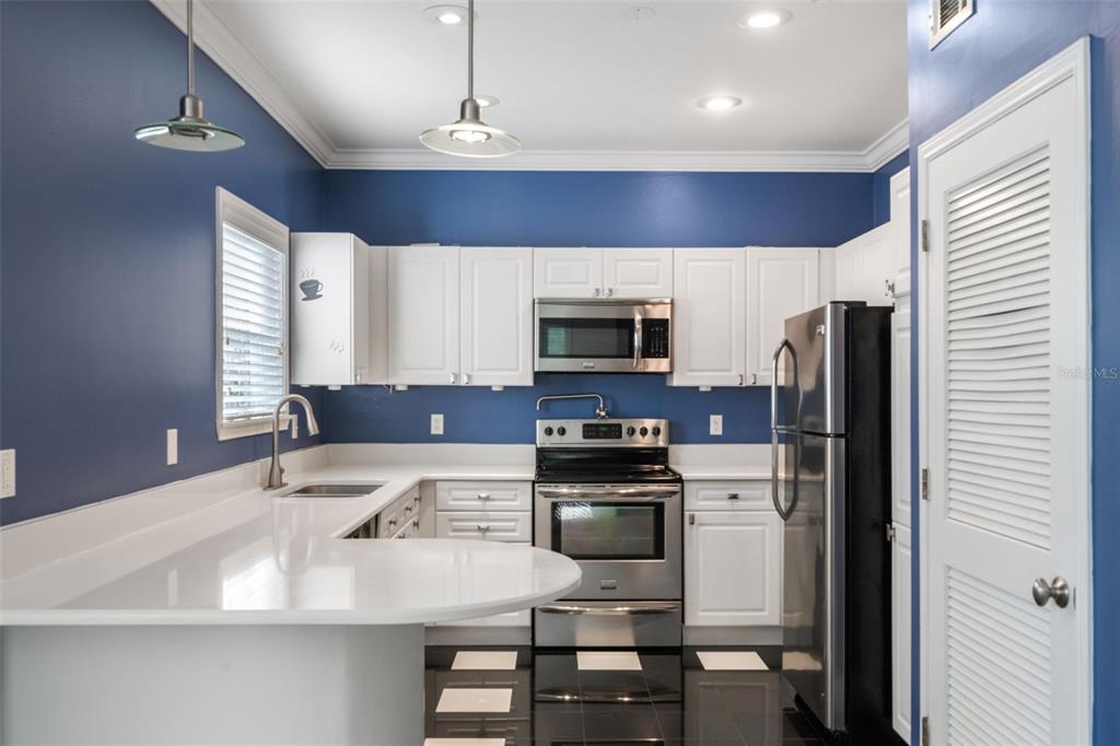 414 Water Street, Unit 414 Celebration, FL 34747 - Photo 15 of 75 a kitchen with stainless steel appliances a microwave a stove and refrigerator