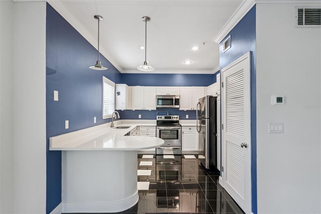 414 Water Street, Unit 414 Celebration, FL 34747 - Photo 16 of 75 a kitchen with stainless steel appliances a refrigerator and a stove top oven