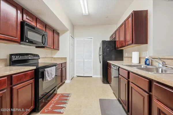 a kitchen with stainless steel appliances granite countertop a sink stove microwave and refrigerator