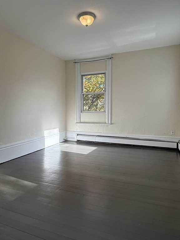 21 Flint Street, Unit 19 Somerville, MA 02145 - Photo 3 of 14 an empty room with wooden floor and windows