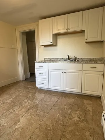 a kitchen with granite countertop a sink and cabinets