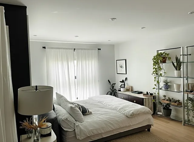 a bedroom with a bed and wooden floor